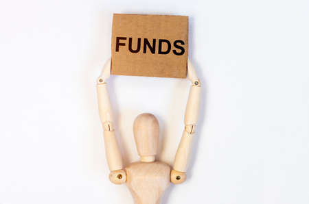 FUNDS word on craft paper holding by a wooden person, financial concept.の写真素材