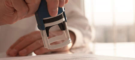 Stamping document close up, seal over contract in male hand. banner