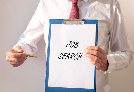 Job Search inscription text on paper board in hands of businessman.の写真素材