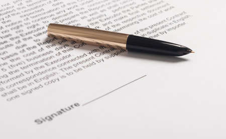 Contract signing concept. golden pen over space for signature on document closeup.の写真素材
