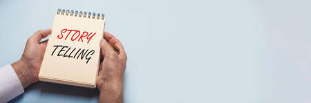 Hand writing Storytelling text Concept in male hands. blue horizontal banner with copy space.