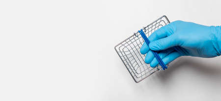 Shopping metal empty basket in male hand in blue protecive glove. shopping during coronavirus lockdown concept, isolated on white background, copy space, banner, place for text.の写真素材
