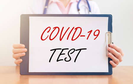 COVID-19 test inscription. Coronavirus concept in doctor hands isolated on white.の写真素材