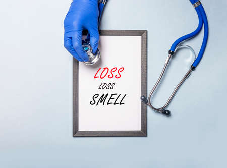 Hands of doctor in gloves holding medical protective mask over stack of masks, top view, banner with...