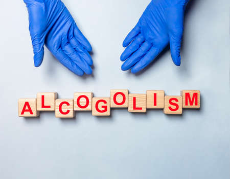 Hands of doctor in gloves holding medical protective mask over stack of masks, top view, banner with copy space.の写真素材