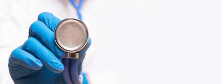Close up of doctor hand with stethoscope directing to camera, copy space, banner.の写真素材