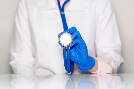 Doctor hands in gloves with stethoscope, medical exam concept.の写真素材