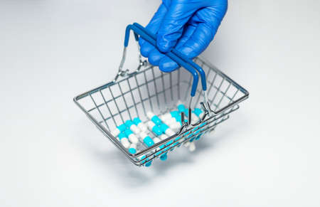 Pharmacy or drugs shopping grocery basket with medicine and pills in pharmaceutist or doctor hands...