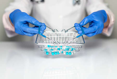 Pharmacy or drugs shopping grocery basket with medicine and pills in pharmaceutist or doctor hands in gloves.の写真素材