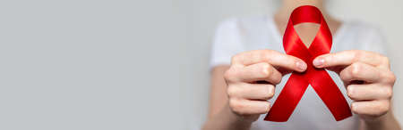 Red ribbon for aids world day support, close up. copy space on banner