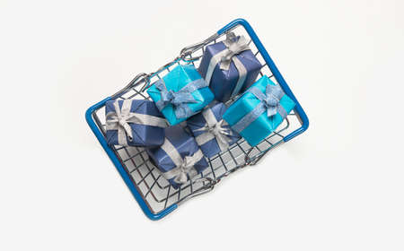 Shopping basket full of blue wrapped gift boxes. Presents for christmas on white background, top...