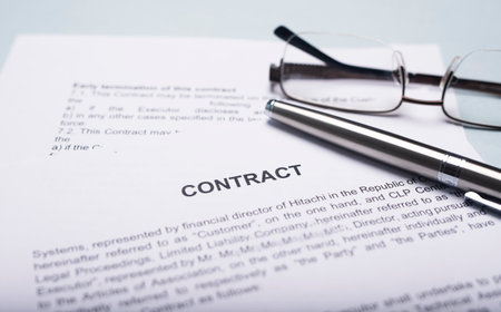 Contract or agreement with pen and eyeglasses on office table. Close up. Concept of concludingの写真素材