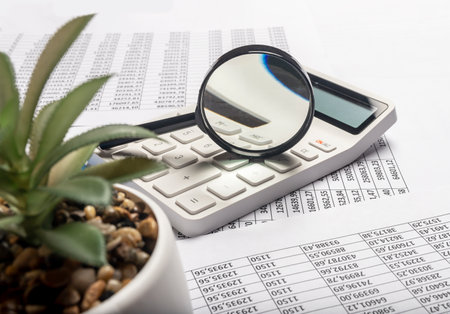 Business financial analysis and research concept. Calculating income and profit. Table full of documents with digits and calculations.の写真素材