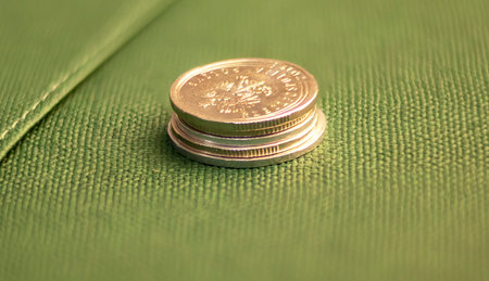 Stack of coins close up on green background. Savings concept.