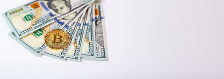 Bitcoin or BTC golden coin with sign of cryptocurrency on banknotes of us dollar with copy spaceの写真素材