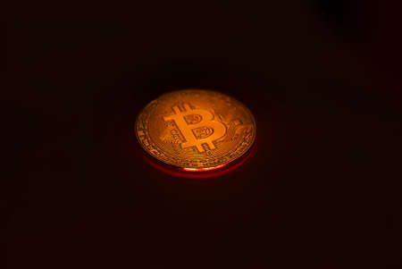 Illuminating Bitcoin coin on black background with copy space for text.