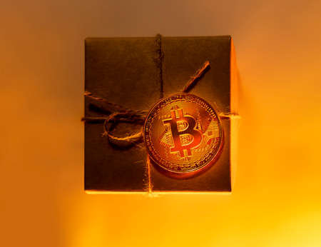Bitcoin coin on gift box or present, monochrome yellow
