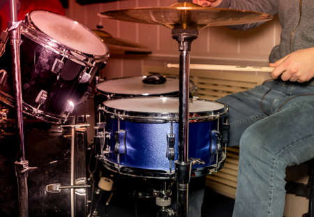 Male hand and drums with metal plates.