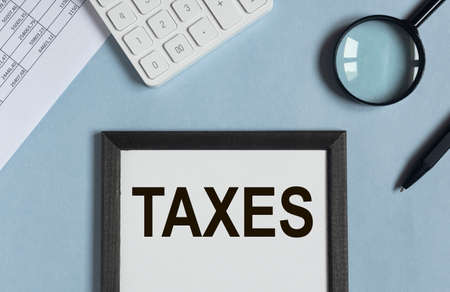 Taxes word on paper, reminder. Taxation concept, accounting and businessの写真素材