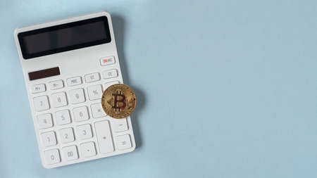 Golden bitcoin on calculator, virtual currency conceptの写真素材