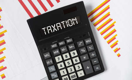 Taxation word on calculator, accounting and bookkeping conceptの写真素材