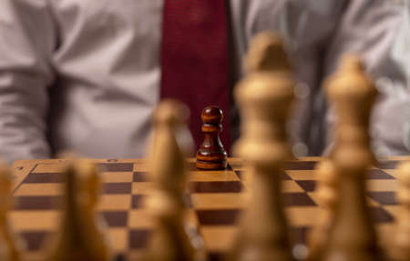 One black pawn against many others. Different against monopoly concept.の写真素材