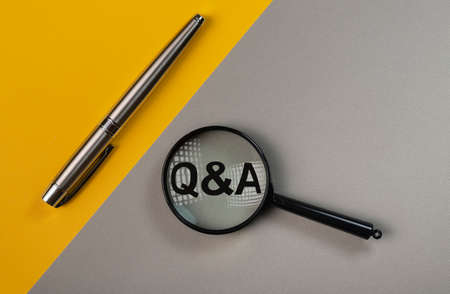 Q or qa concept through magnifying glass on yellow and gray colored background.