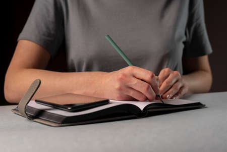 Female hands making records and notes, making appointments, planning in planner.