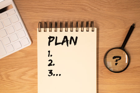 Word plan on sheet of planner or notebook. Financial goals concept.
