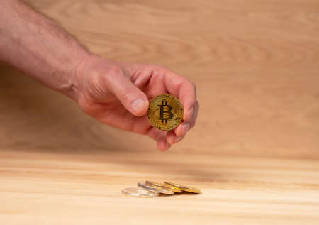 Bitcoin golden coin in male hand. Cryptocurrency and crypto investment.の写真素材