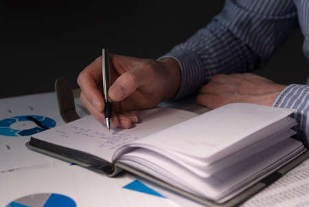 Businessman at desk with financial documents, preparing finance report, budget analysis in charts.