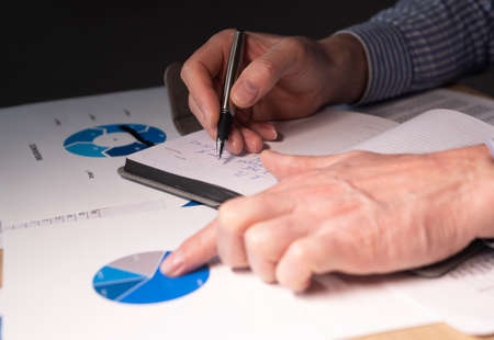 Businessman at desk with financial documents, preparing finance report, budget analysis in charts.