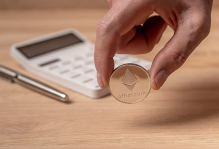 Silver etherium coin on calculator. Cryptocurrency in accounting concept.の写真素材