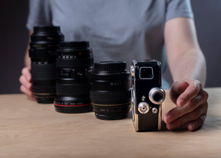 Photographer showing camera development from vintage old one to different modern lenses. Photograph...