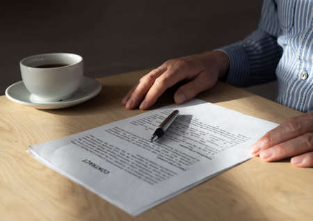 Man reading contract to sign it at office desk.の写真素材