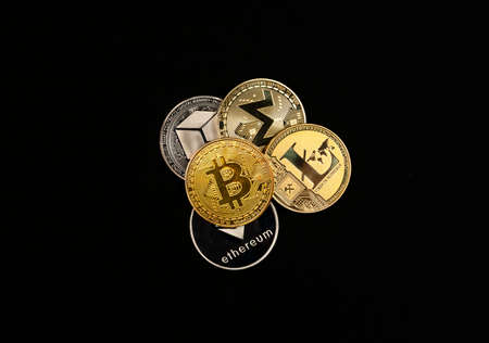 Shining cryptocurrency coins heap on black background, top view of bitcoin, monero, litecoin,...