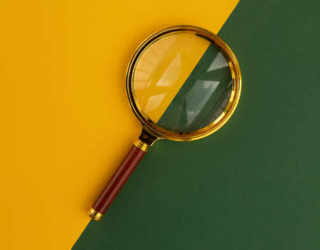 Magnifier over yellow and green background. Search tool.の写真素材