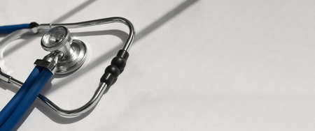 Metal blue sthethoscope on white banner with copy space for text.