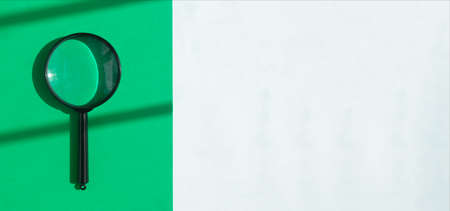 Magnifying glass over eco green and white banner. Search tool on minimalistic background with copy space.の写真素材
