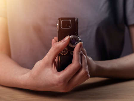 Female hands holding old antique vintage film camera. Retro photo lense.の写真素材