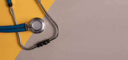 Medical banner with stethoscope on gray and yellow background with copyspace for text.の写真素材