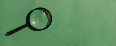Magnifying lens over green background with copyspace. Eco banner with magnifier and place for text.の写真素材