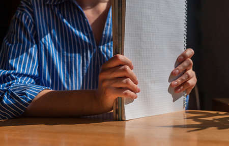 Closeup women hands holding stack of documents, financial papers or business report over wood office desk with day light.の写真素材