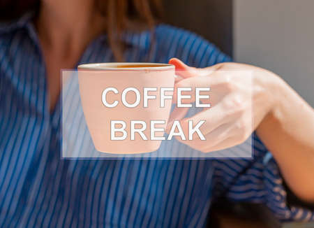 Coffee break inscription on photo with hand holding coffe cup.の写真素材