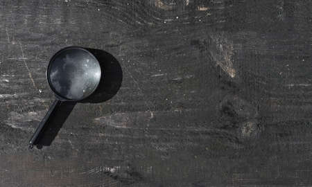 Magnifying lens on wood old background with copy space. Wooden banner with magnifier.の写真素材