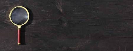 Magnifying glass on wood background with copy space for text. Banner with copyspace.の写真素材