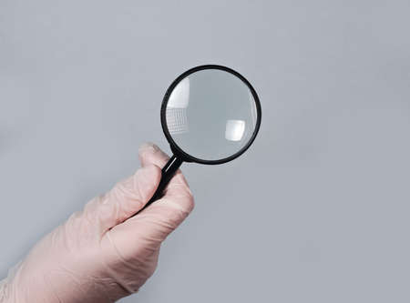 Doctors hand hold magnifying glass, searching treatment and examining diseases with optical lens concept.の写真素材