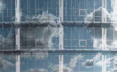Sky and clouds in reflection of glass window. Modern architecture in detail.の写真素材