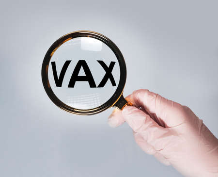 Vax word. Medical vaccination concept through magnifierの写真素材