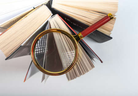 Magnifier over open paper book. Concept of knowledge, research and studying.の写真素材